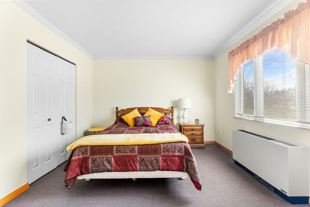 Bedroom with bed, closet, nightstand, and window with a view.