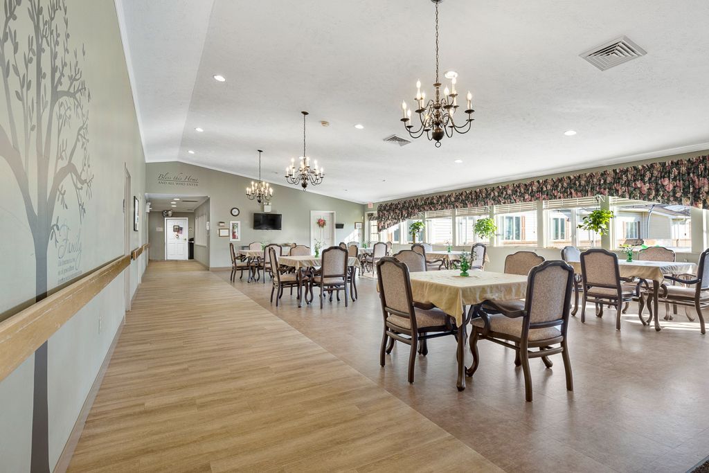 Dining room with tables, chairs, chandeliers, and a hallway with a mural.