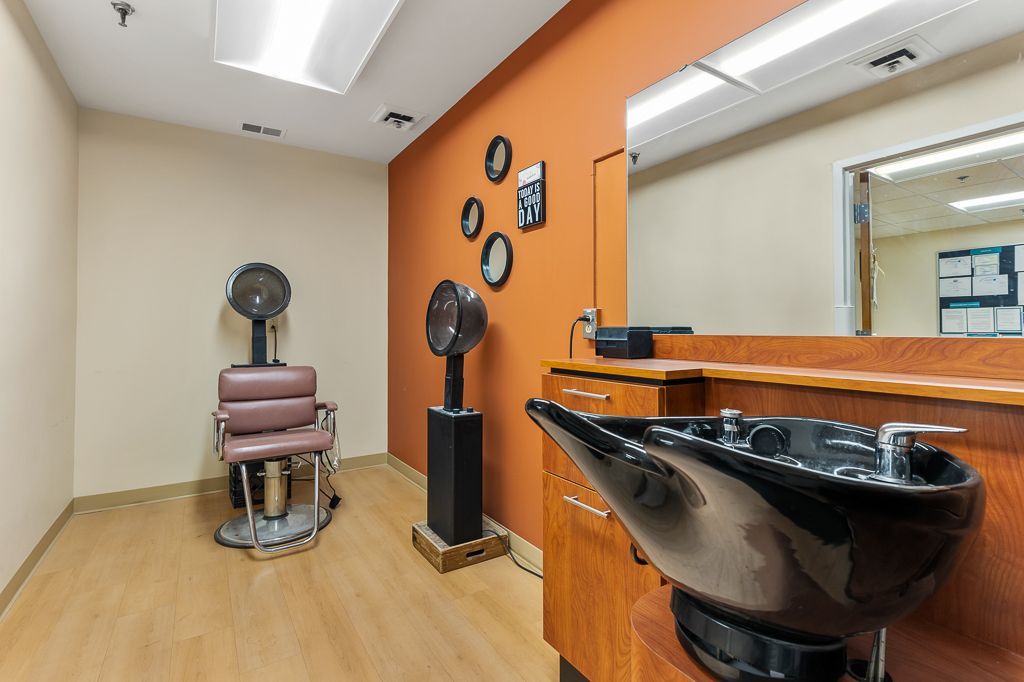 Hair salon interior with styling stations and a vintage dryer chair.