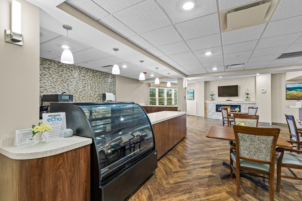 Cafe interior with coffee counter, tables, chairs, and stone wall feature.