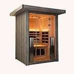 Small wooden sauna cabin with glass front door and warm interior lighting