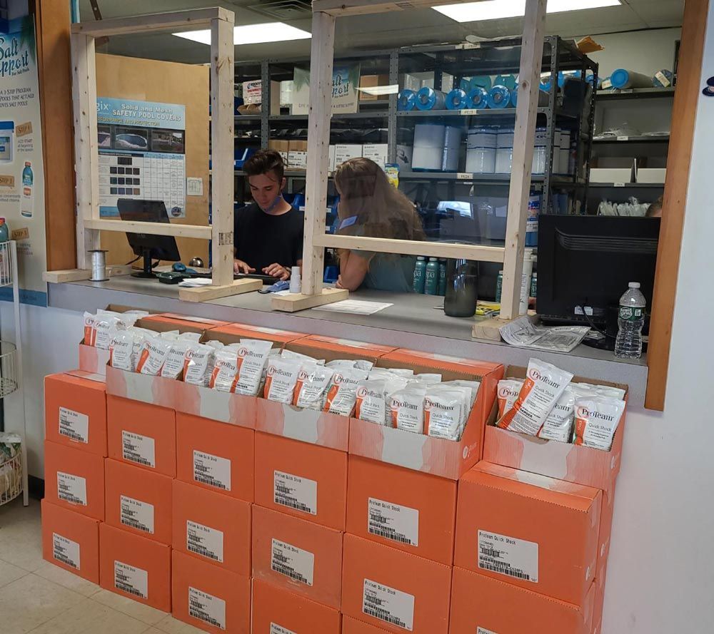 Volunteer table with orange donation boxes and people sorting items behind a wooden counter