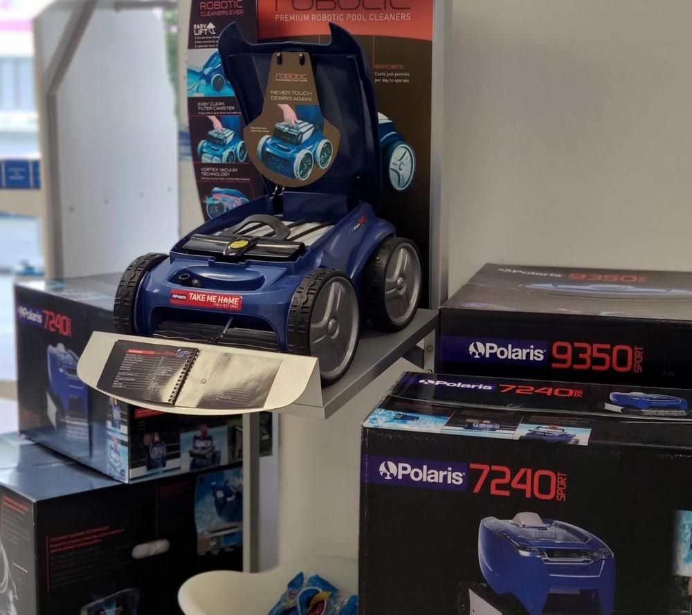 Display of boxed Polaris ride-on vehicles, including a blue kids' motorcycle and black 4-wheelers.