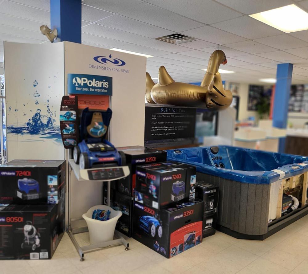 Store display with box fans, blue pool, and a gold inflatable swan in a retail aisle