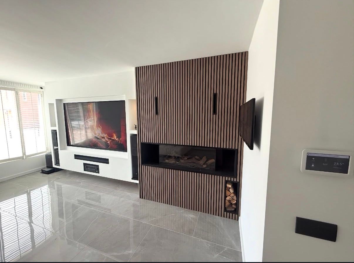 Moderne woonkamer met een grote tv, glanzende vloer en een accentmuur met gestreepte houten open haard.