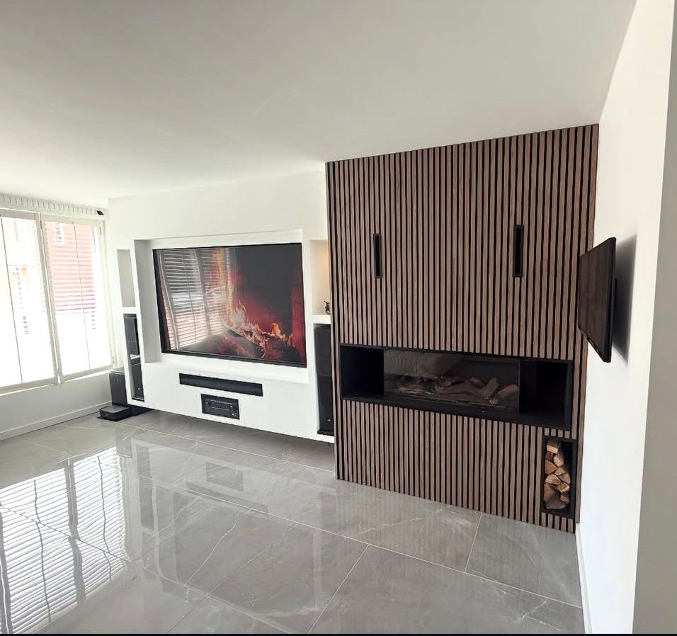 Moderne, lege woonkamer met glanzende tegelvloer, grote tv, open haard en accentmuur van houten latten.