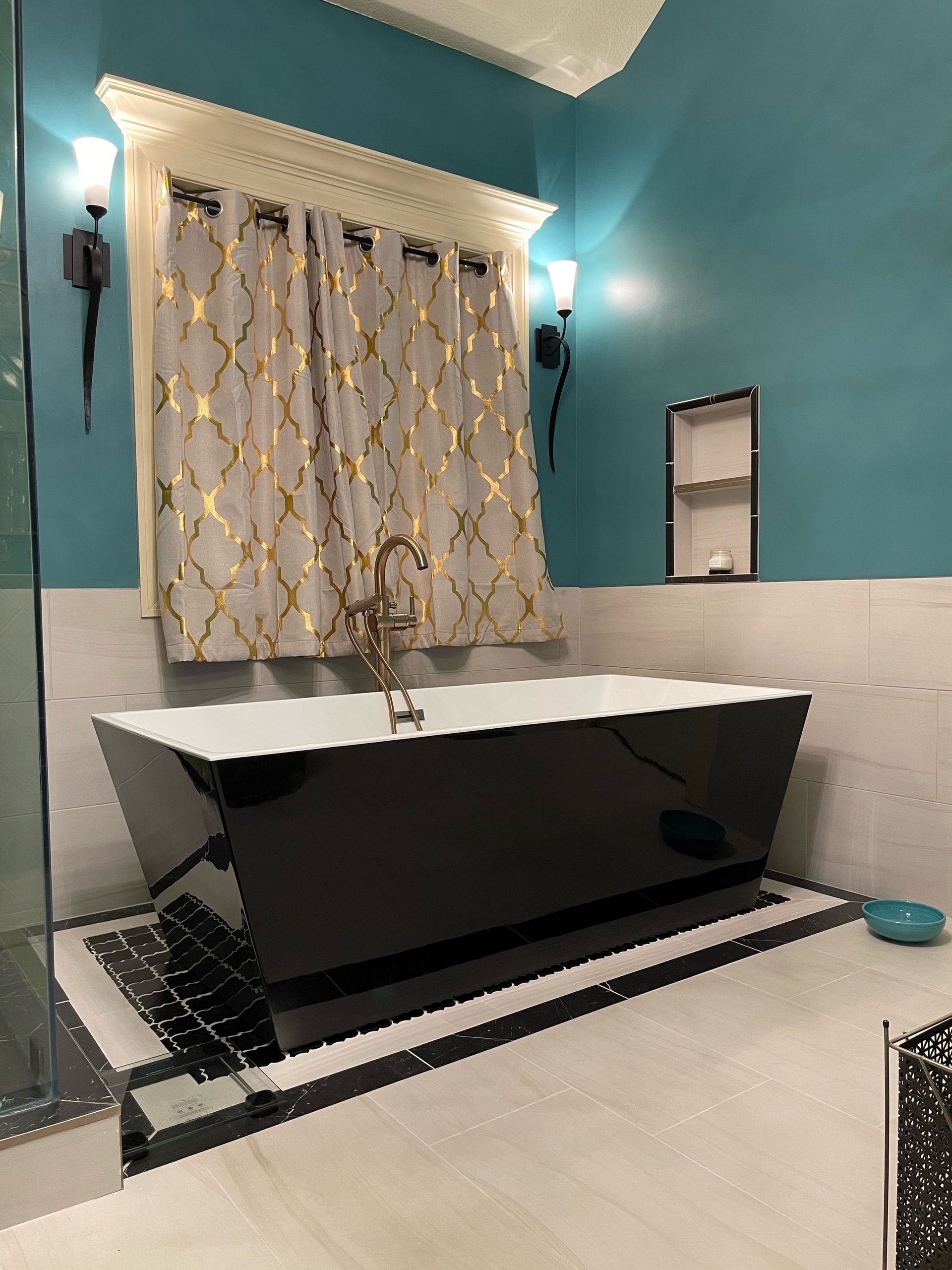 A bathroom with a black tub and blue walls.