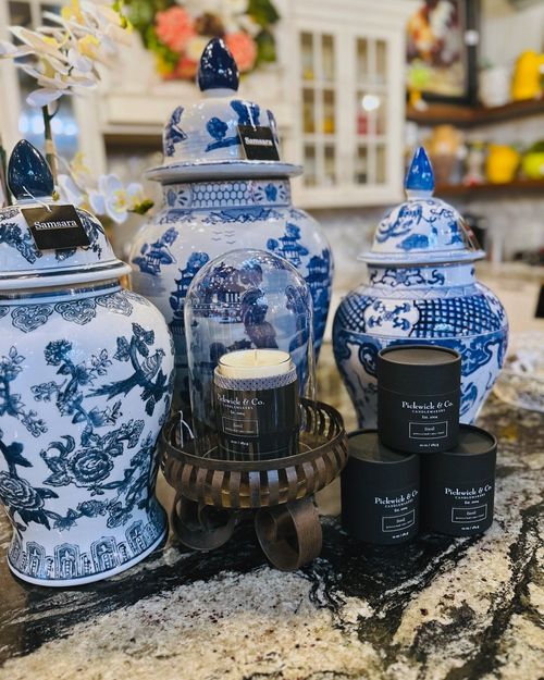 A table topped with blue and white vases and candles.