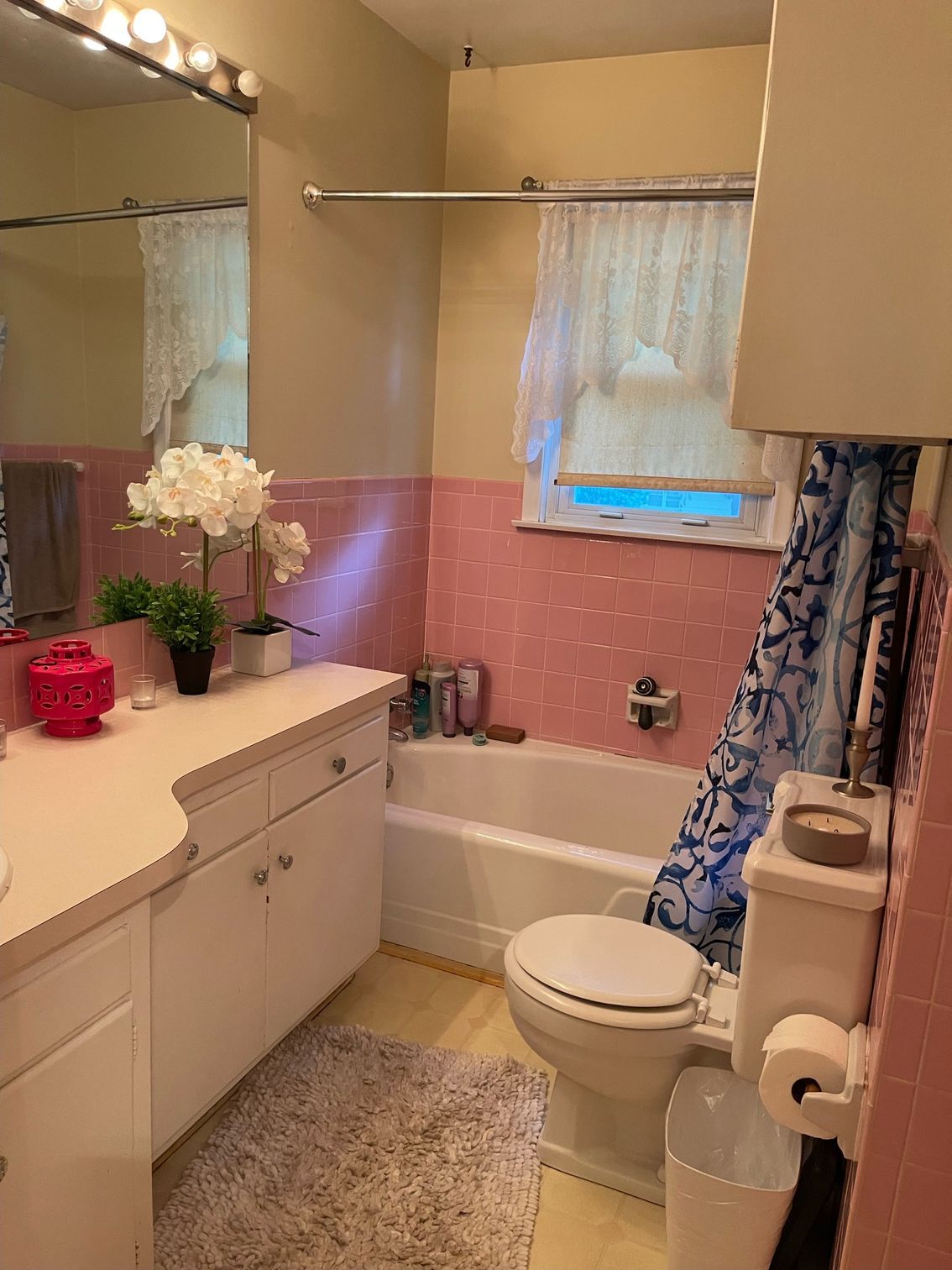 A bathroom with a toilet , sink , tub and mirror.
