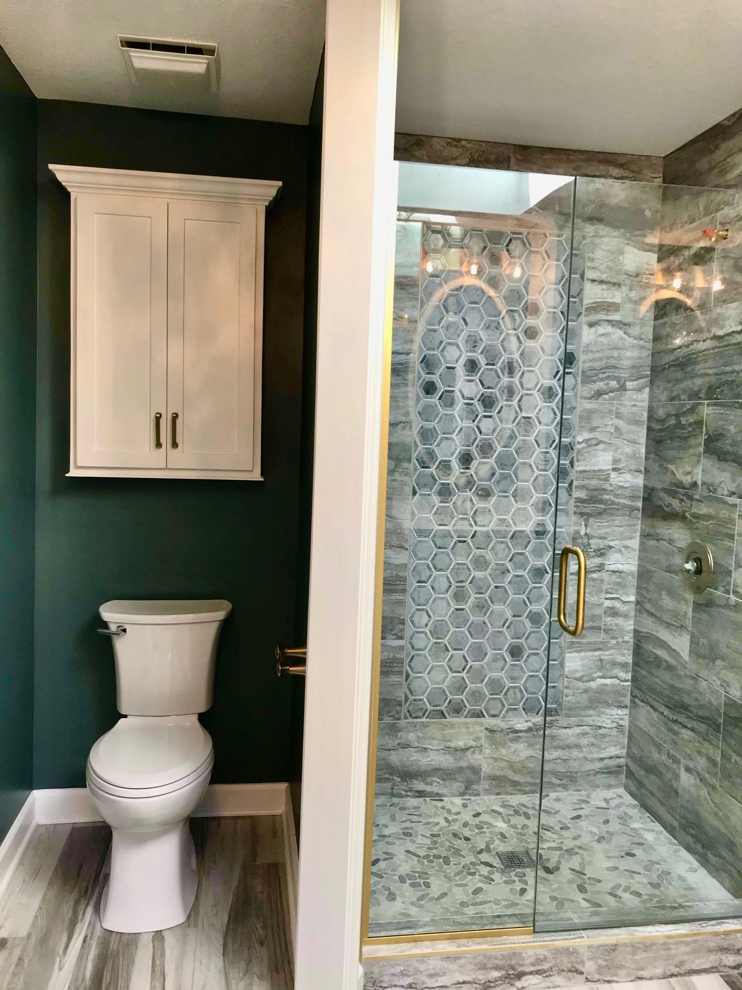A bathroom with a toilet and a walk in shower.