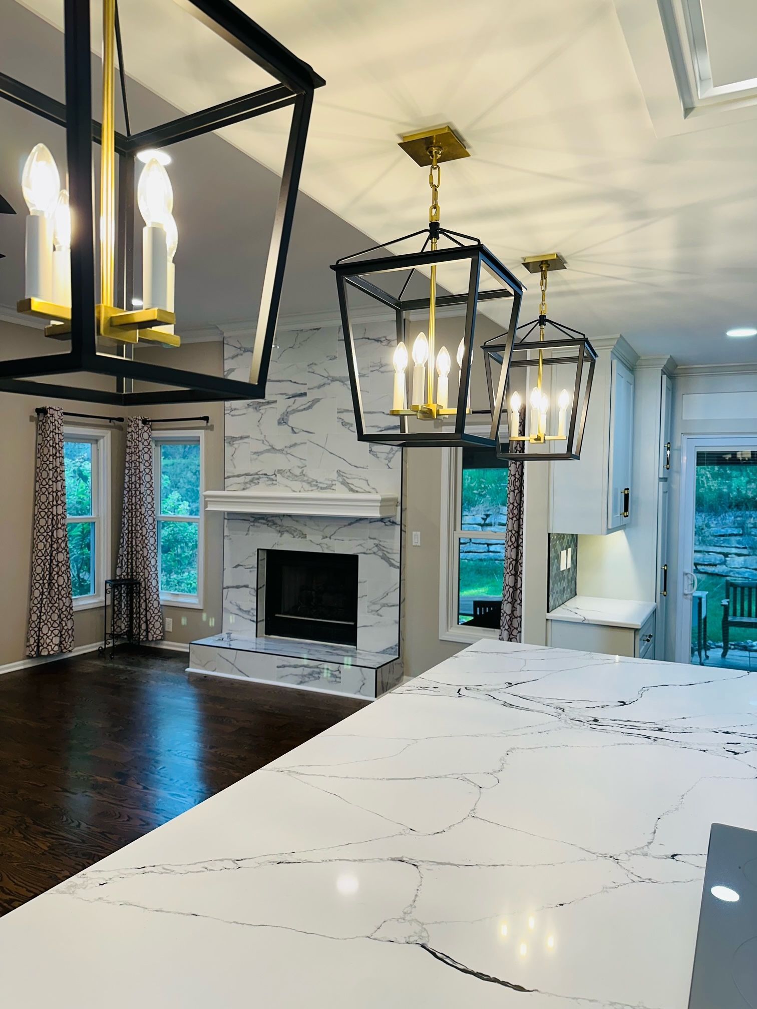 A living room with a fireplace and lanterns hanging from the ceiling