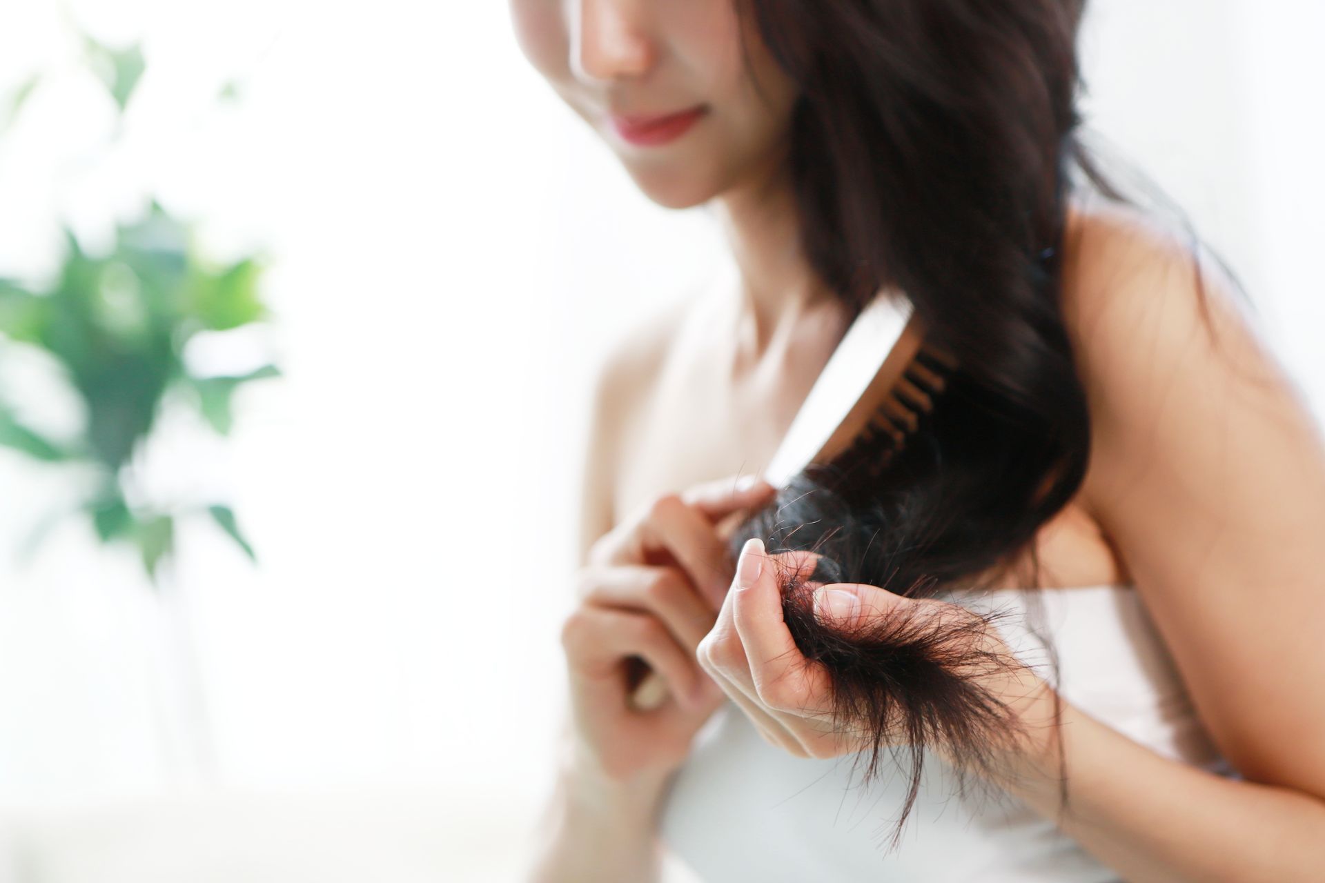 Una donna si spazzola i capelli con una spazzola.