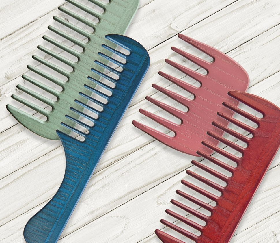 Un pettine blu e un pettine rosso sono su una superficie di legno