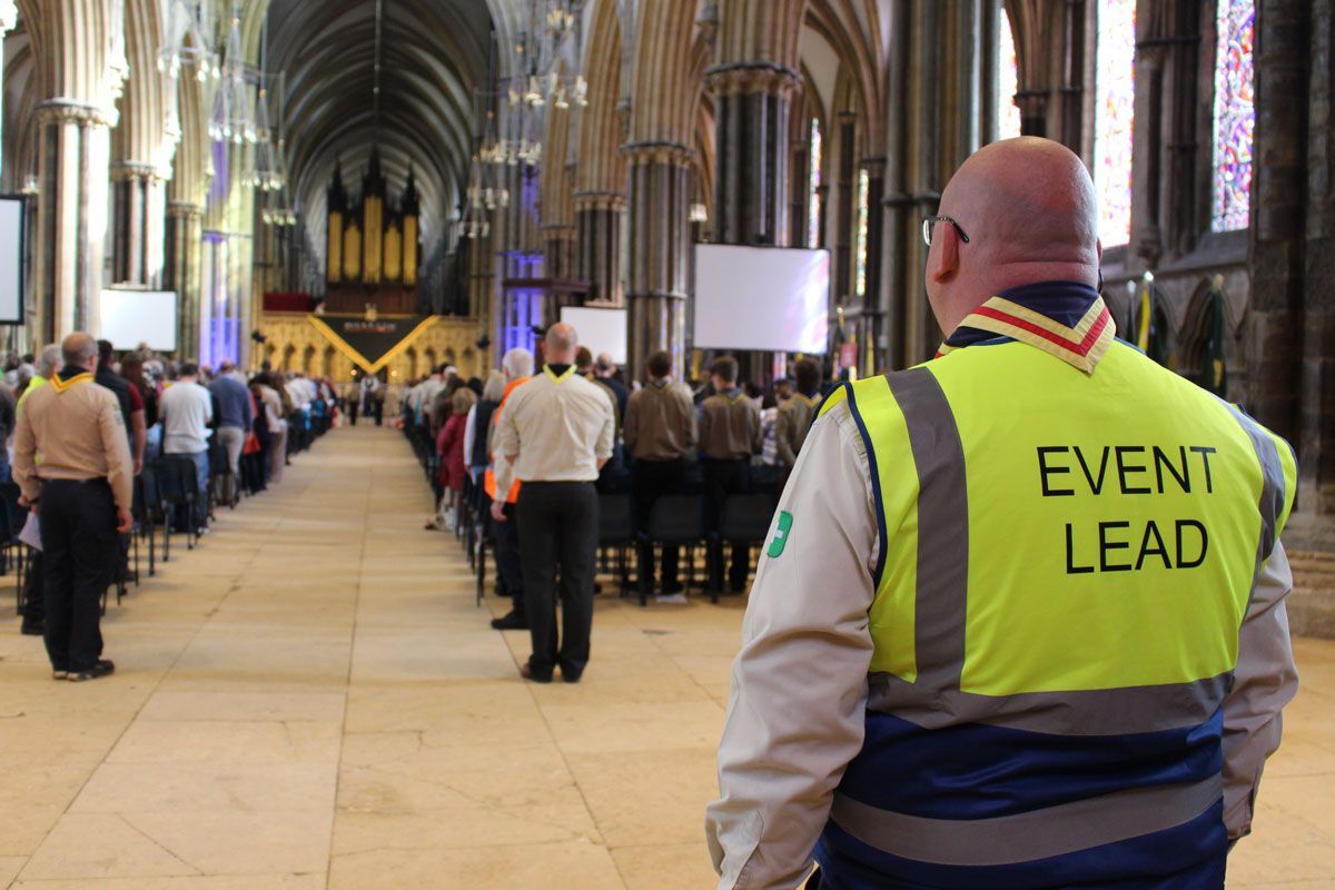 Lee, Lincoln District Lead Volunteer, in an Event Lead hi-vis vest overlooking a Scout service.