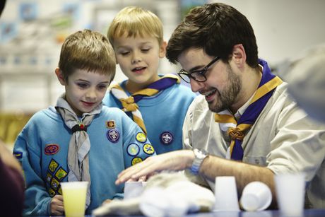 Beaver Scouts working with their leader learning new skills together.