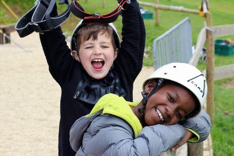 Cub Scouts smiling and celebrating while taking part in outdoor adventure activities.