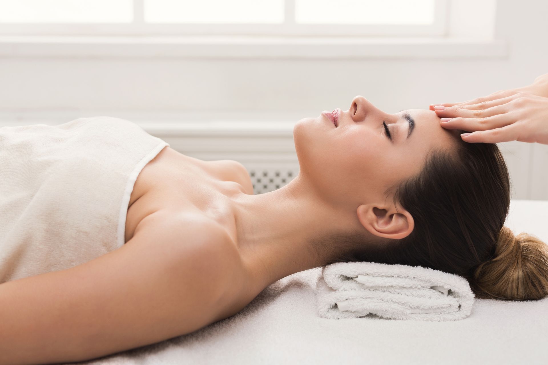 A woman is getting a head massage at a spa.