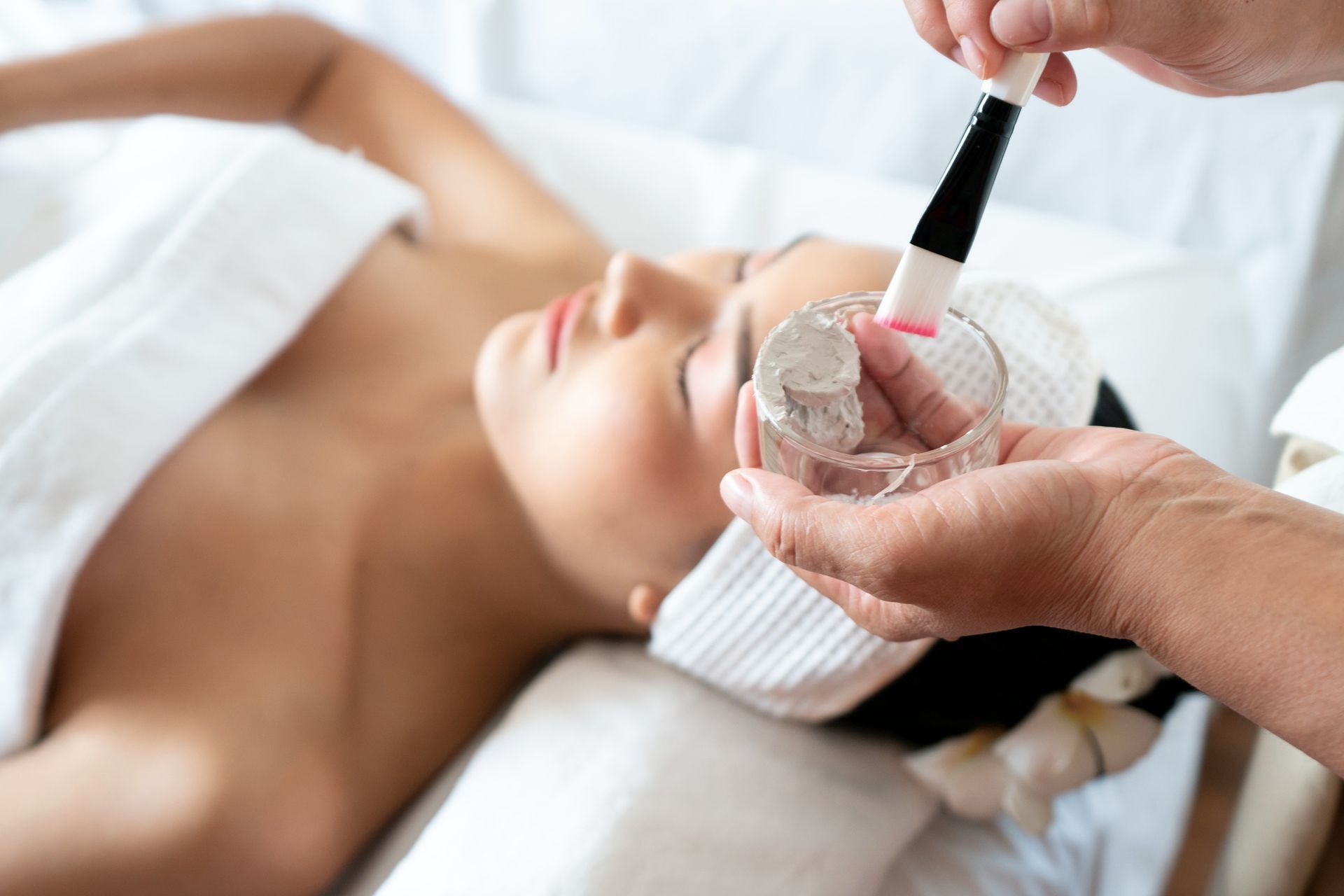A woman is getting a facial treatment at a spa.