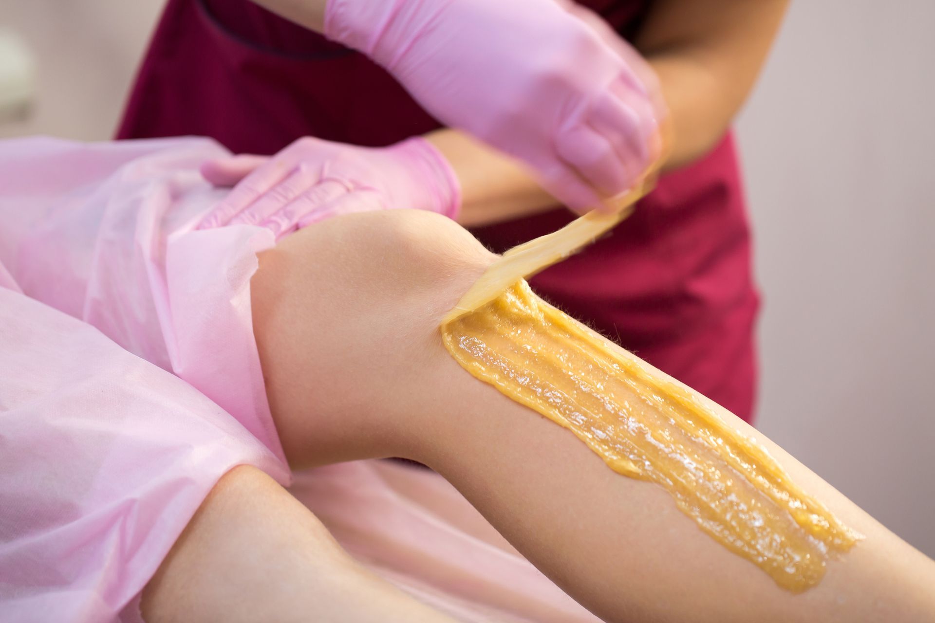 A woman is getting her legs waxed in a beauty salon.