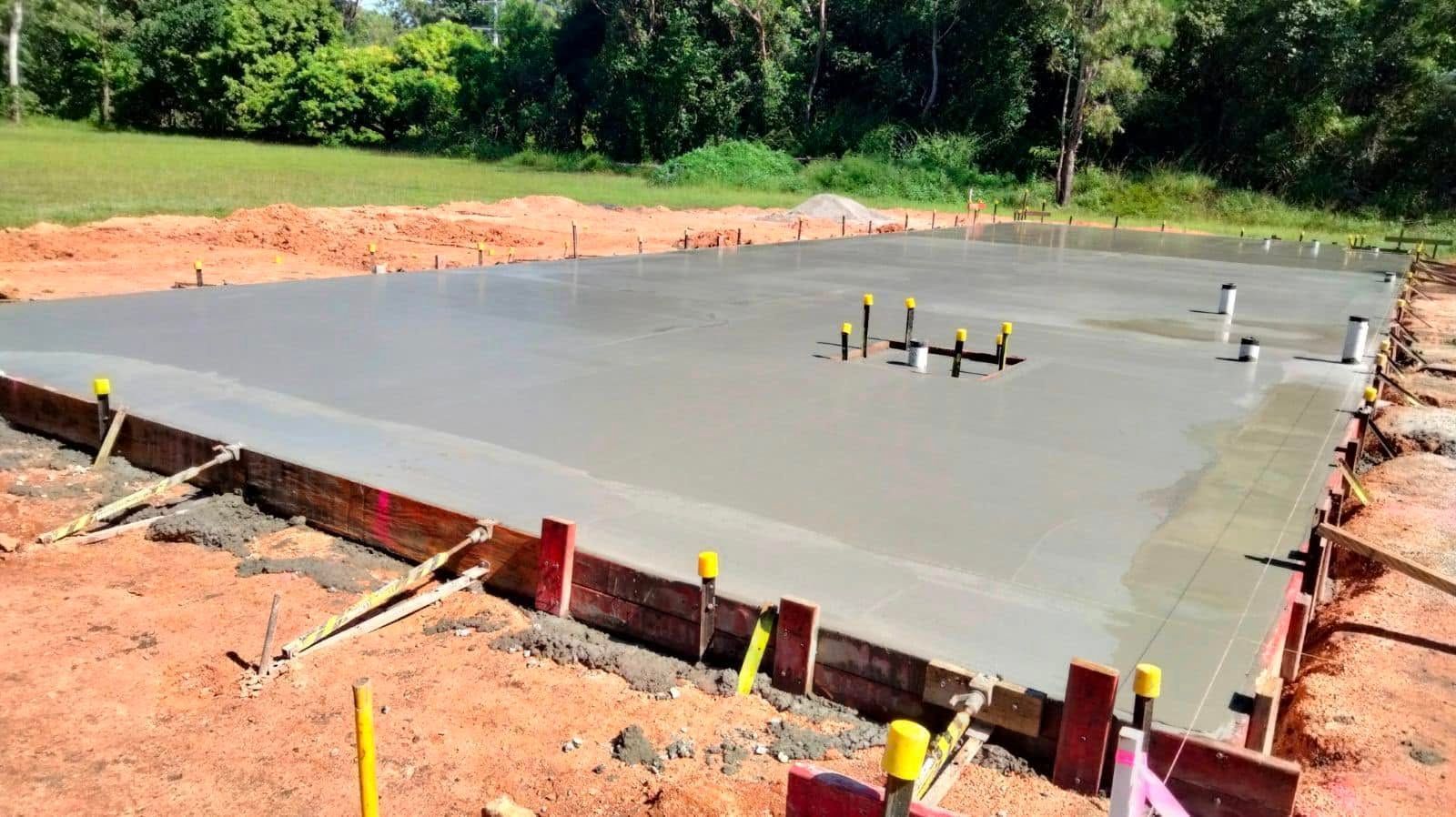 Freshly Poured Concrete Slab Under Construction With Yellow Markers — King Reef Concrete in Kurrimine Beach, QLD