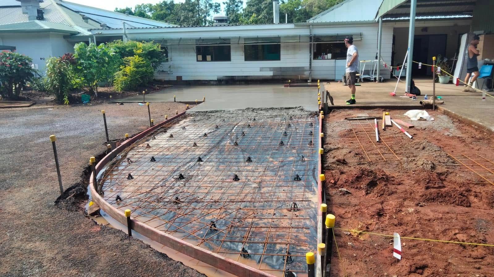 Construction Workers Pouring Wet Concrete Into a Wooden Foundation Form — King Reef Concrete in Cardwell, QLD