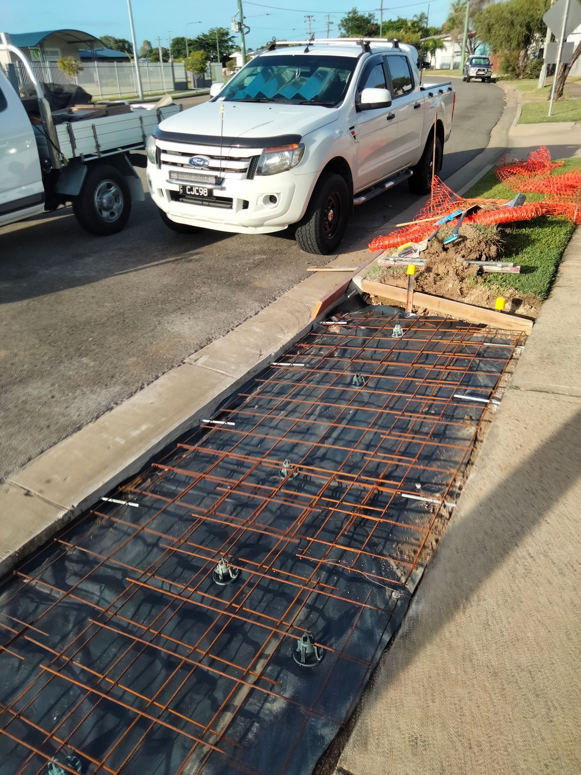 White pickup truck beside damaged sidewalk ramp with bent metal railing and debris on the curb — King Reef Concrete in Kurrimine Beach, QLD