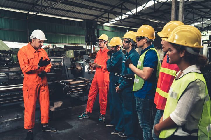 Un gruppo di operai edili si trova in una fabbrica.