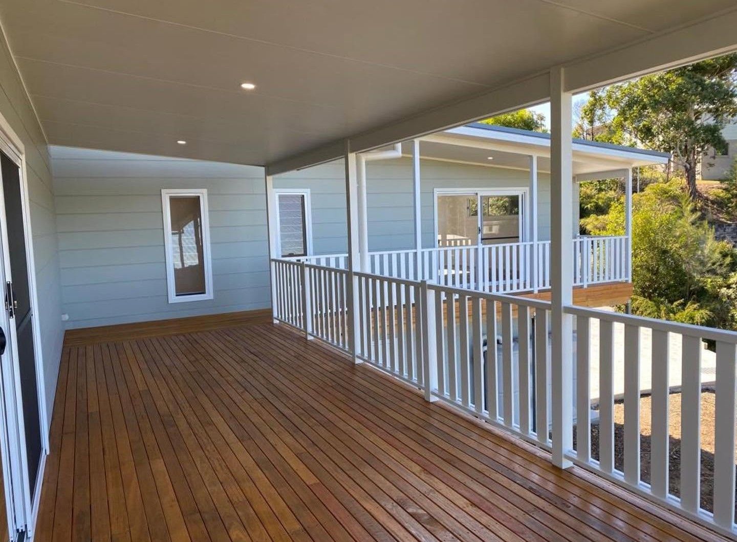 Builder Forster Covered Timber Deck With Modern White Railings