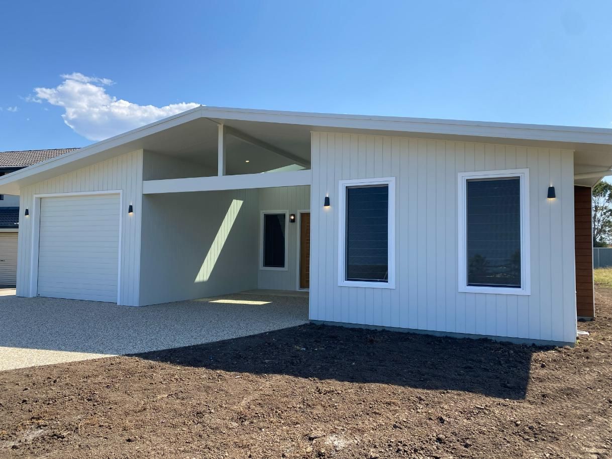 White Modern House With a Garage and Two Tall Windows — Mid North Coast Drafting & Construction in Nabiac, NSW