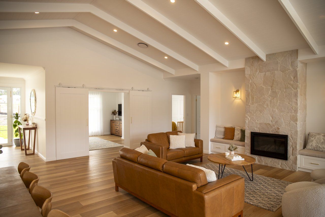 Bright Living Room With Wood Floor, and Stone Fireplace — Mid North Coast Drafting & Construction in Taree, NSW