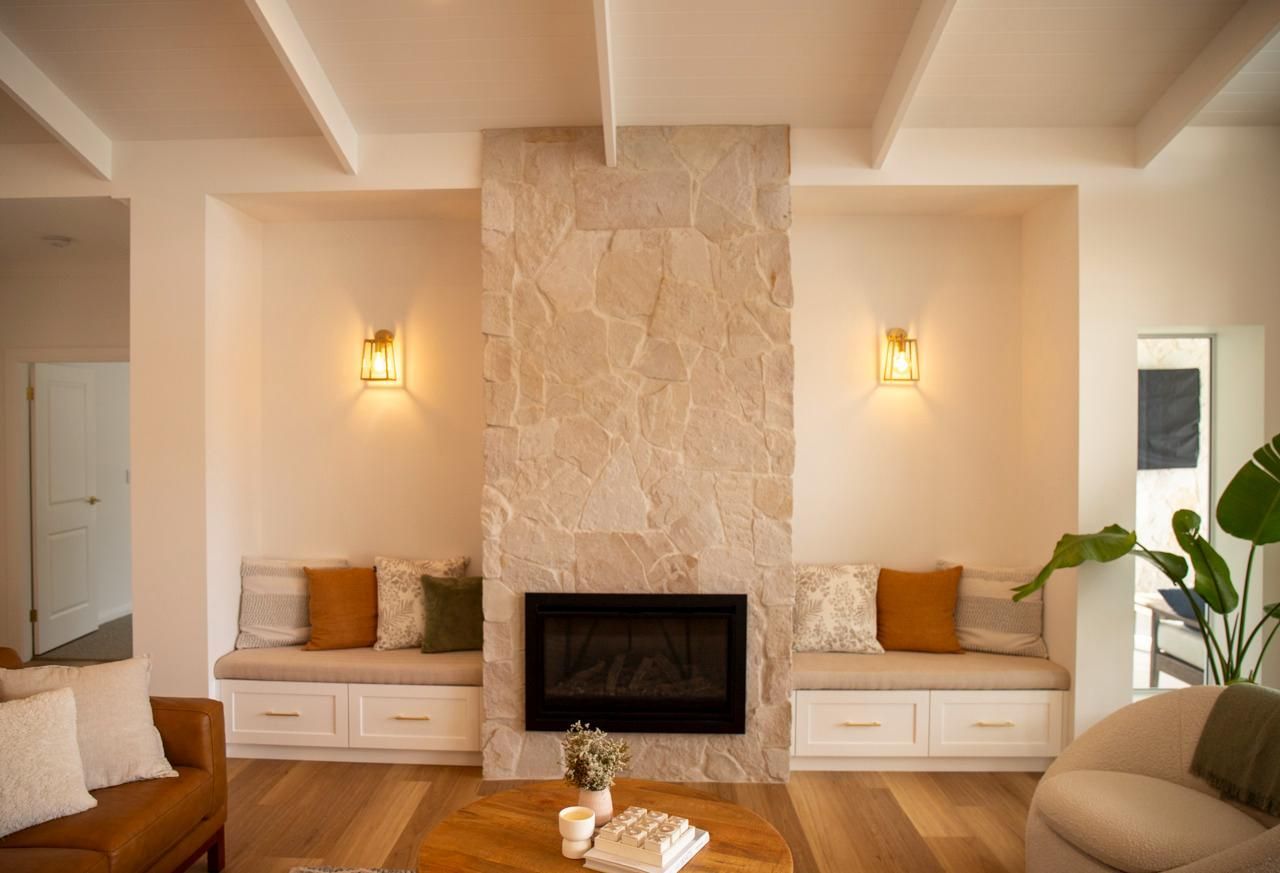 Living Room With Stone Fireplace, Benches, and Wooden Floors — Mid North Coast Drafting & Construction in Taree, NSW
