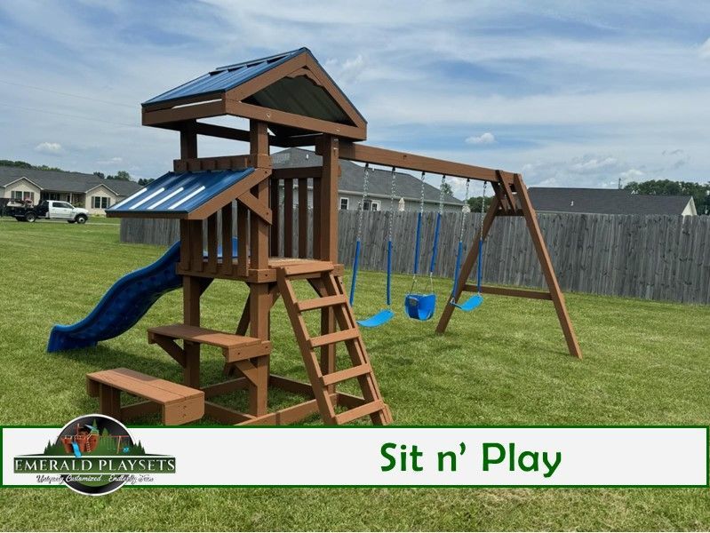 A wooden playground set with a slide and swings in a grassy yard.