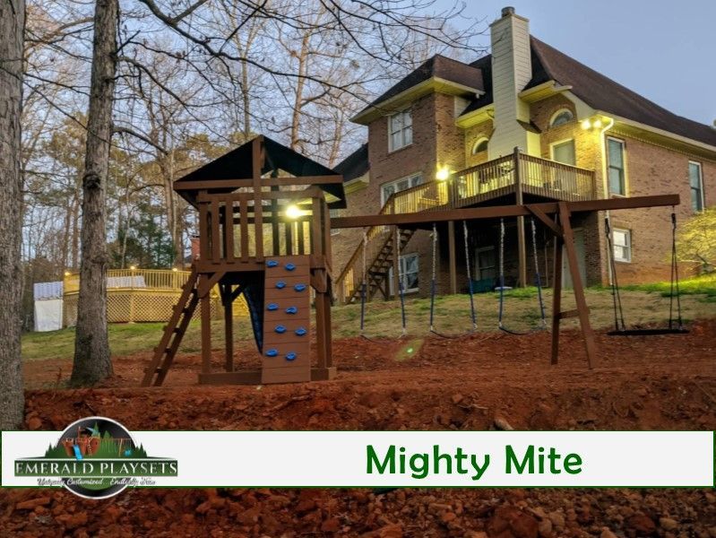 A house with a playground in front of it that says mighty mite