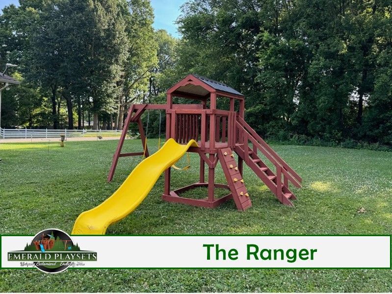 A wooden playground with a yellow slide and a sign that says the ranger