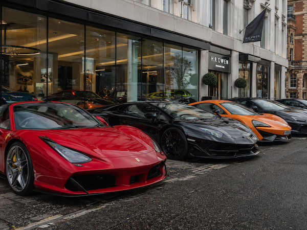 Ferrari, Lamborghini and McLaren supercars outside a luxury dealership, for the Supercars and High-Value Vehicles card