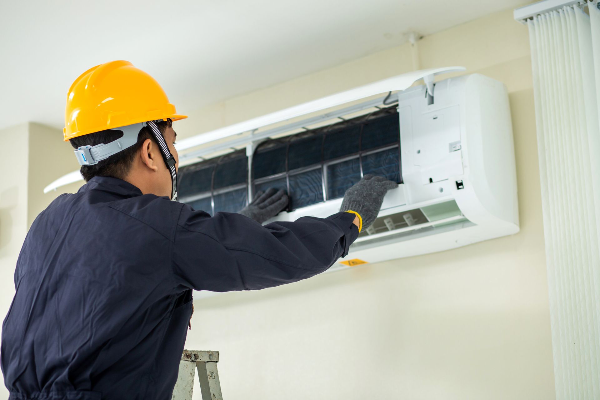A technician is checking an AC unit.