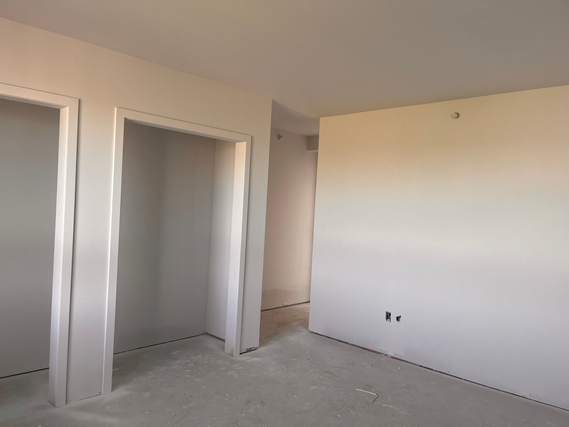 Pièce vide avec murs et portes en plaques de plâtre, construction inachevée.