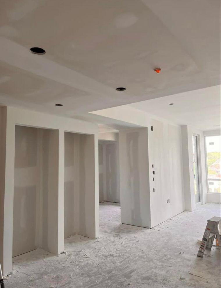 Intérieur d'une pièce en construction avec cloisons sèches et éclairage encastré.