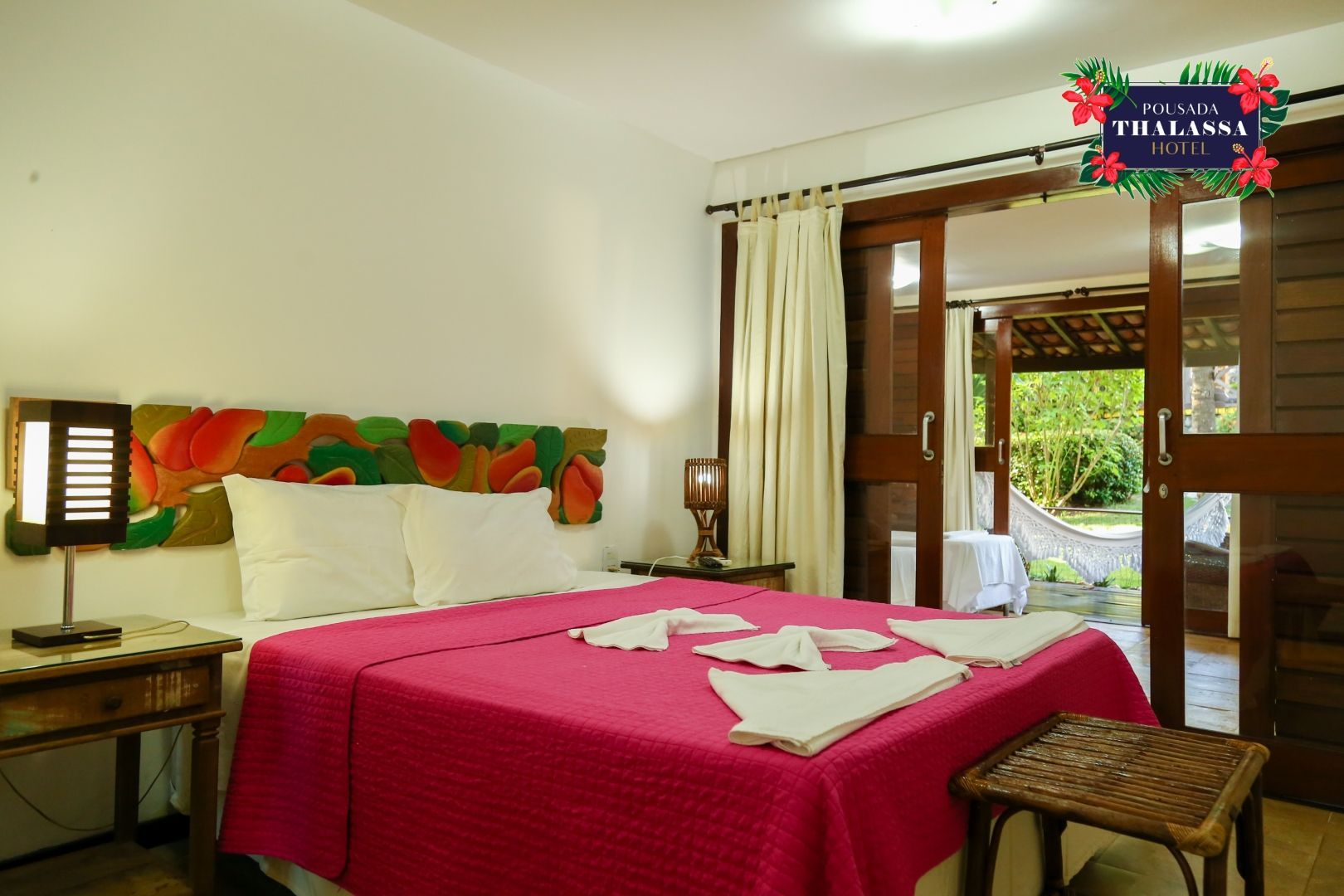 Um quarto de hotel com uma cama grande e uma porta de vidro deslizante