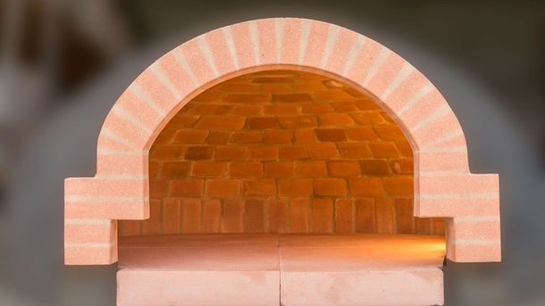 Forno o camino ad arco rivestito in mattoni con apertura interna incandescente