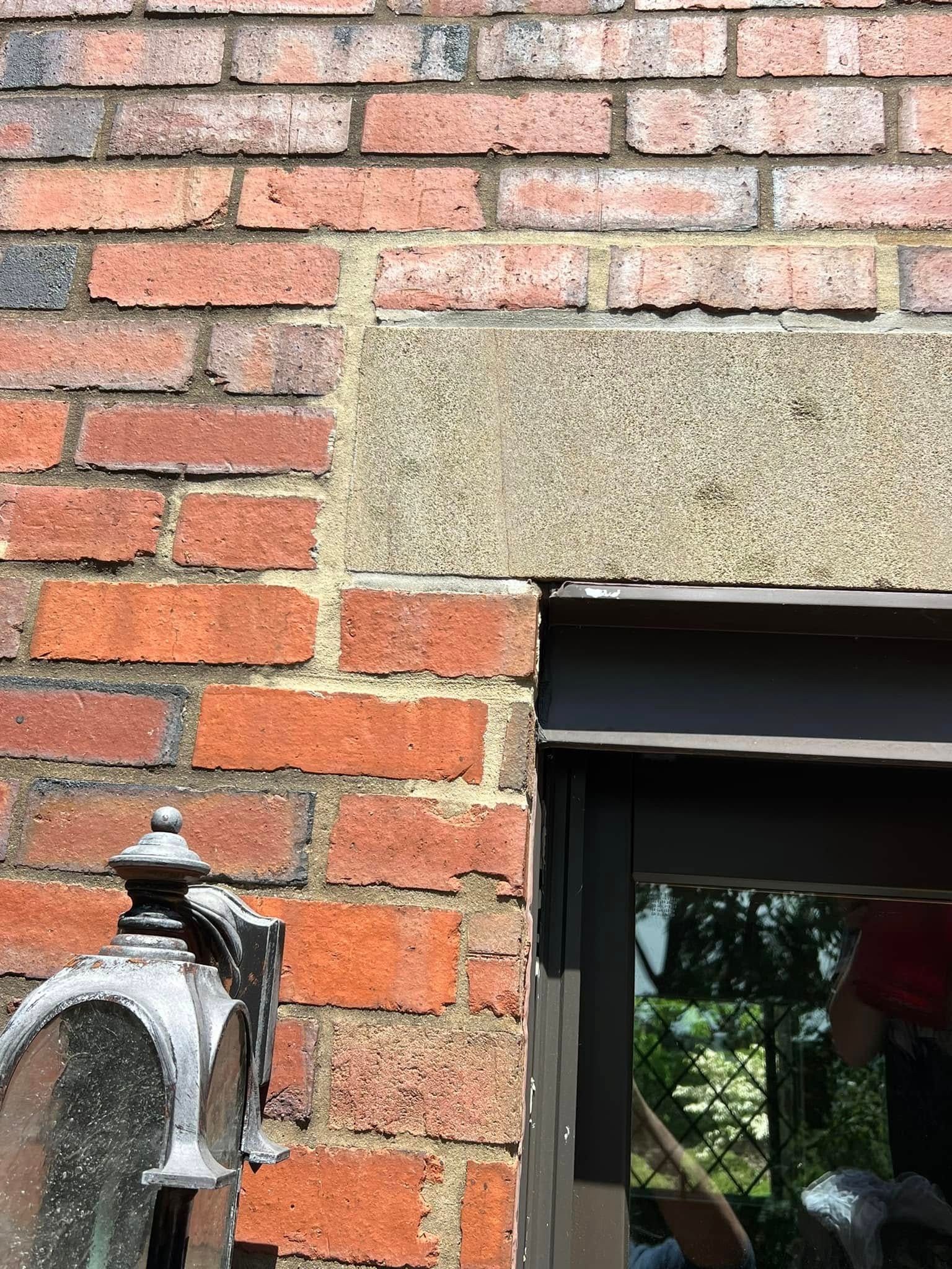 Brick wall with a window and a black outdoor lantern on the left