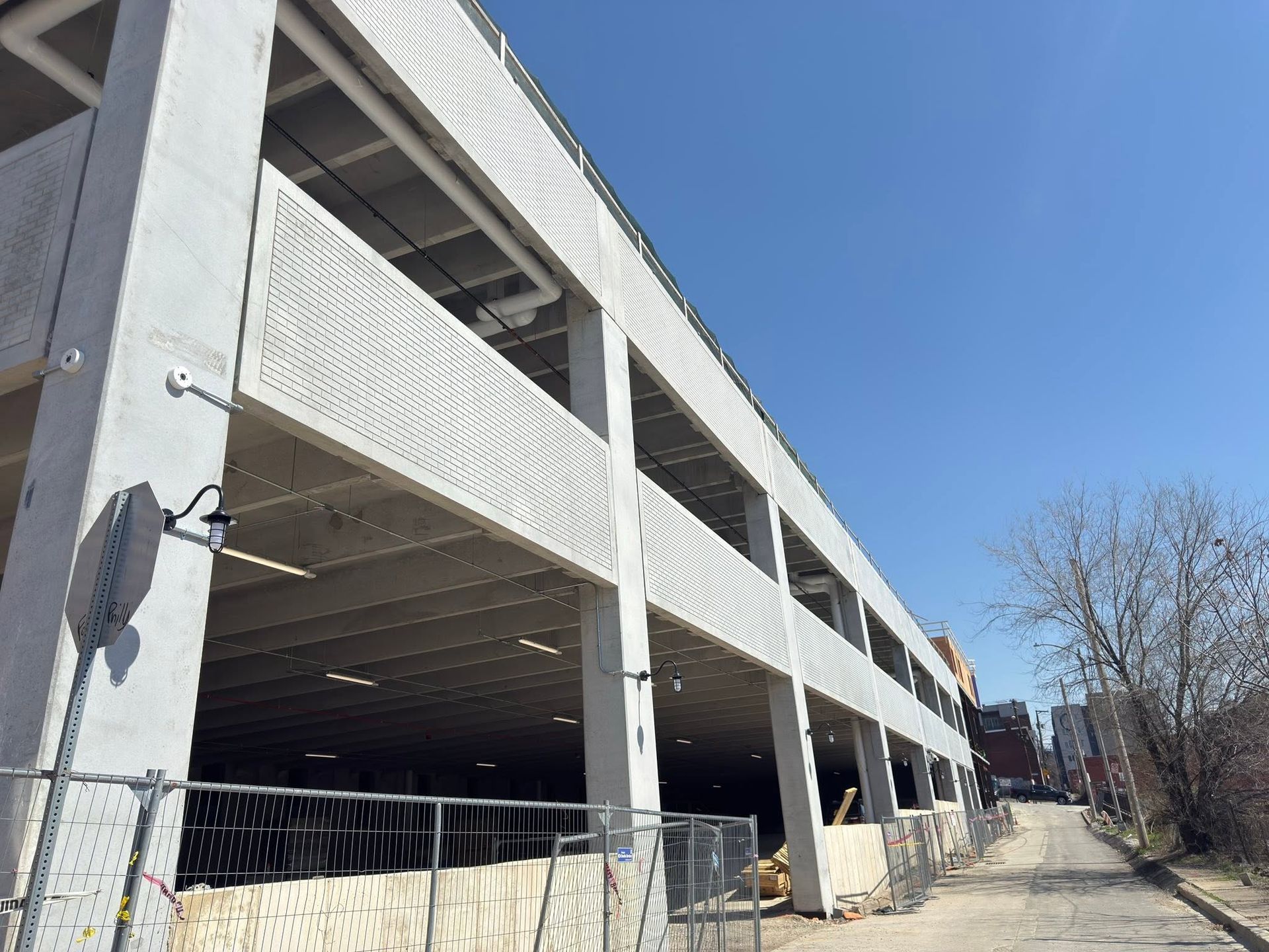 Multi-level parking garage with white railings and open bays under a clear blue sky