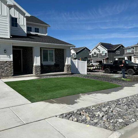 Suburban house with a front lawn, driveway, and parked car on a sunny day