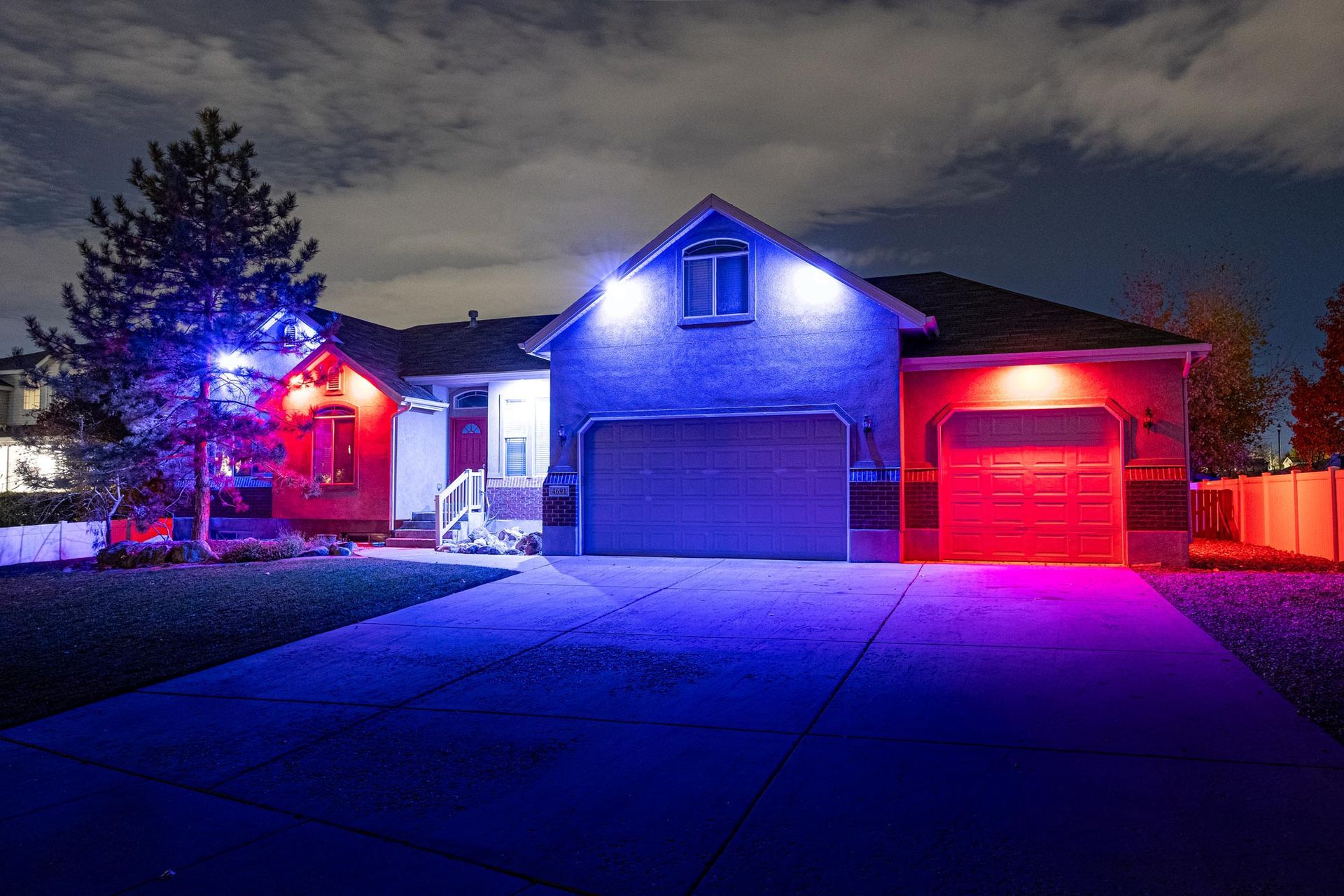 A house is lit up with blue and red lights at night.
