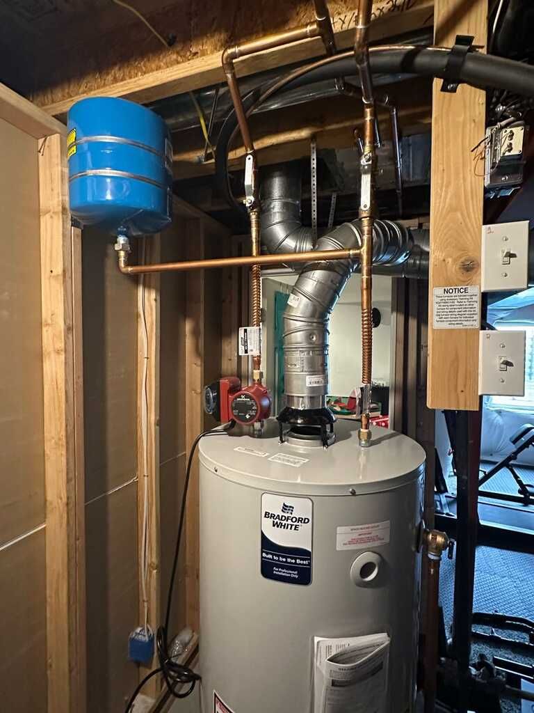 Water heater and ductwork in a utility closet with exposed pipes and a blue expansion tank.