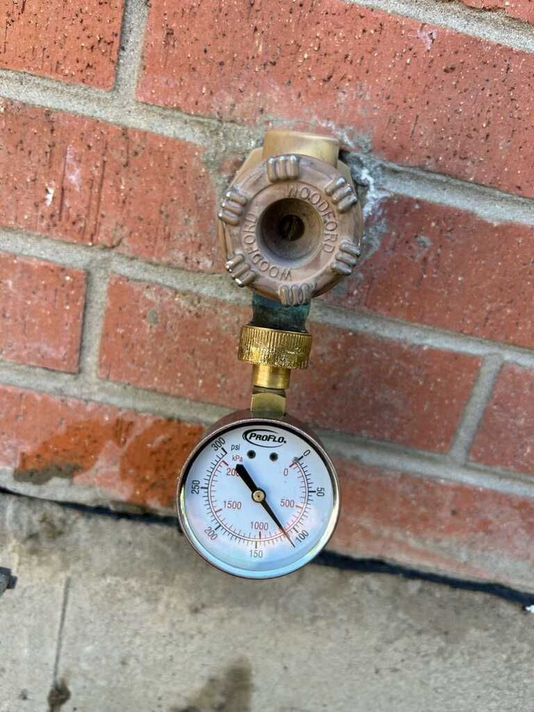 Gas shutoff valve with pressure gauge mounted on a brick wall