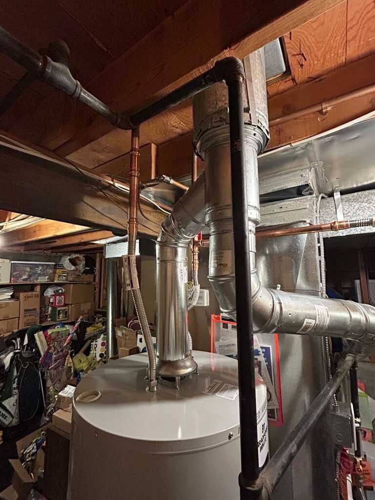 Basement utility area with furnace, ducts, pipes, and exposed ceiling joists.