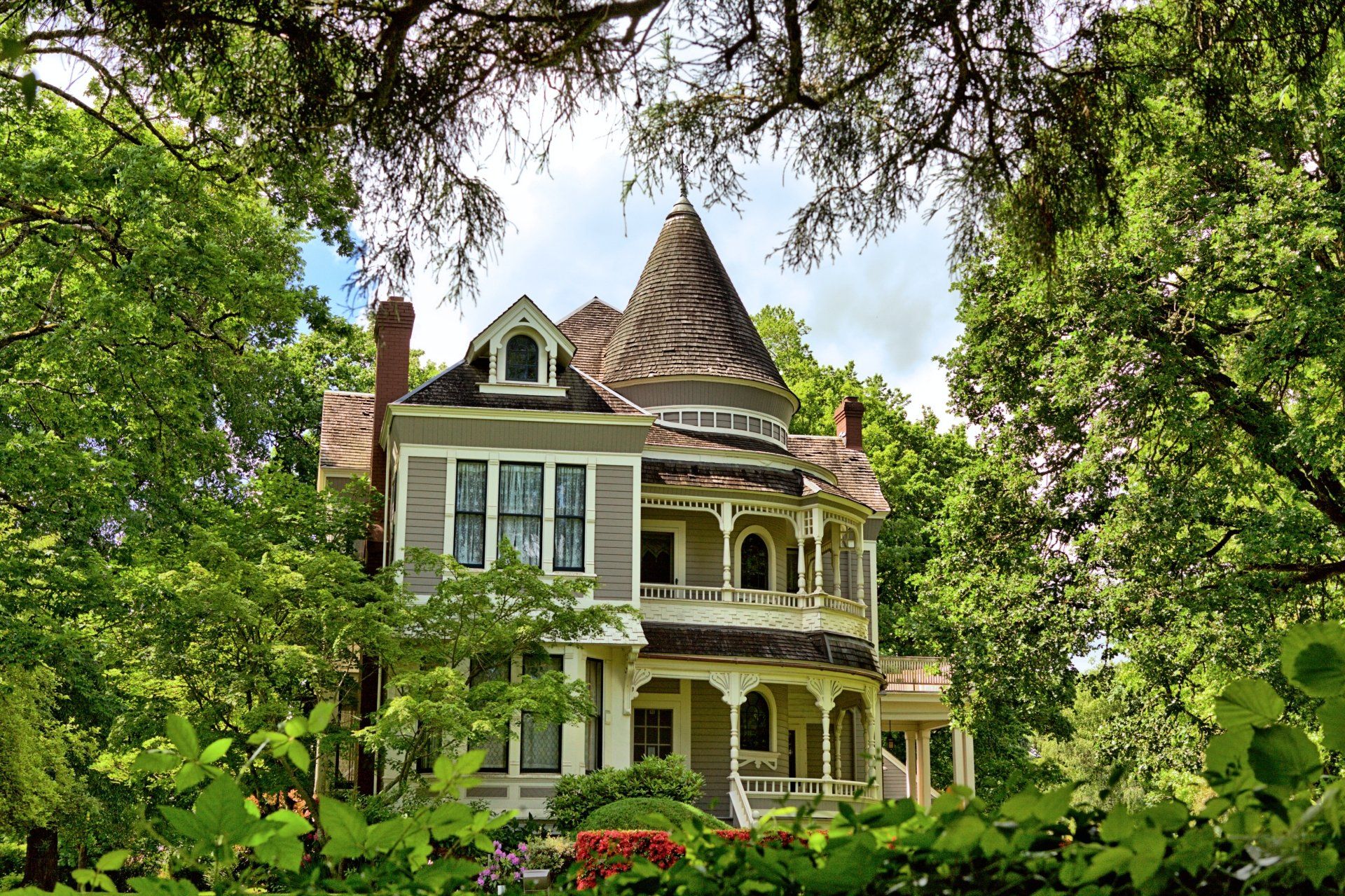 a large house with a tower on top of it is surrounded by trees .