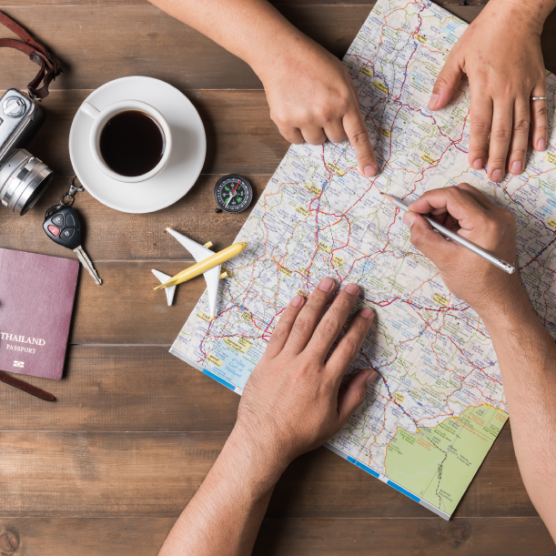 Two people are looking at a map on a wooden table
