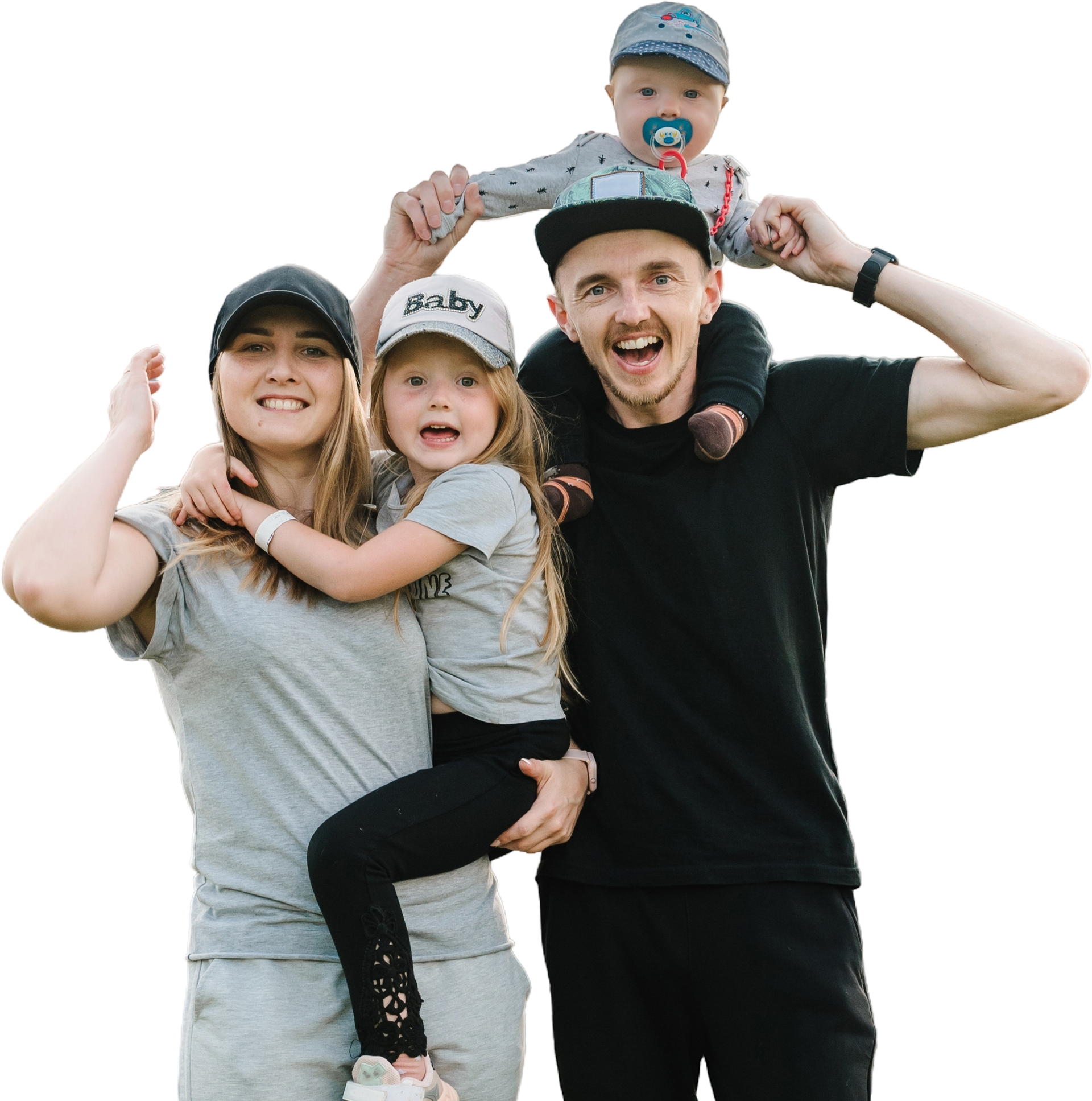 A family is posing for a picture with a baby on a man 's shoulders.